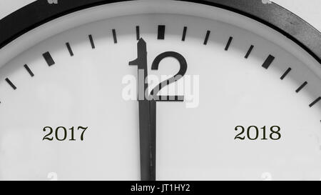 Nahaufnahme auf das schwarze Zeiger von einem weißen Hintergrund Umlauf Kennzeichnung eine Minute vor Mitternacht, markiert das Ende des Jahres 2017 und Anfang 2018. Stockfoto