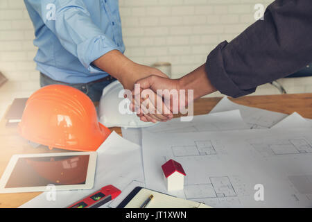 Ingenieur und Architekt, Ingenieur Architekten Büro Team arbeitet Hand mit Blueprints und Haus Modell auf Büro Schreibtisch, Vintage Effekt Stockfoto