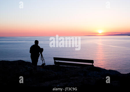 Mann-Fotografen Fotografieren von Sonnenuntergang am Meer Stockfoto