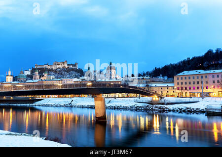 Schöne Aussicht auf die Altstadt von Salzburg mit Salzach Fluss im Winter während der blauen Stunde, Salzburger Land, Österreich Stockfoto