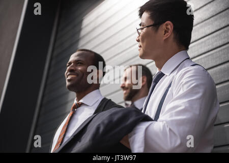 Junge stilvolle multiethnischen Geschäftsleute in formale stehen im Freien, Business Team Meeting Stockfoto