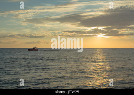 Kleines Boot auf dem Sunset Licht, Port in Riga, Lettland, industrielle Transport Hintergrund Stockfoto