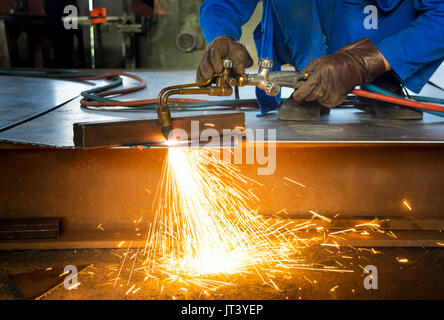 Man Schneiden von Metall mit Feuer aus einem Schweißen Schneidbrenner Stockfoto