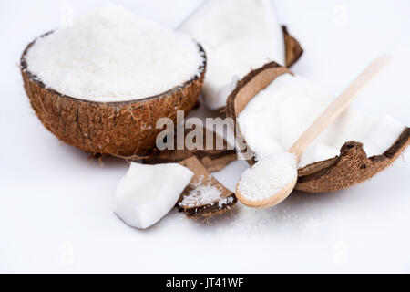Reif organische Kokosnuss mit süßen Späne mit Holzlöffel isoliert auf weißem Stockfoto