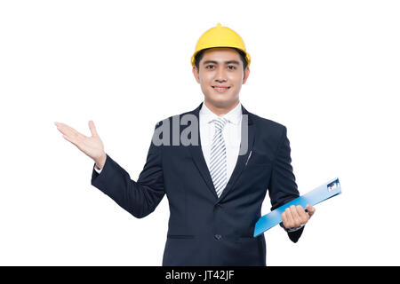 Der junge Architekt Mann mit hardhat Holding Zwischenablage und Geste Stockfoto