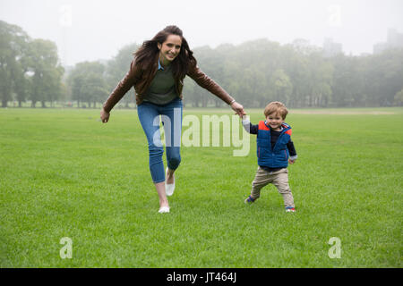 Glückliche Mutter spielt mit ihren Toddler Sohn im Freien. Liebe und Zweisamkeit Konzept. Stockfoto