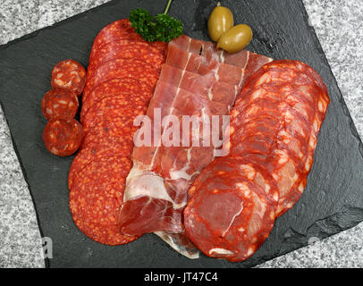 Auswahl an Tapas, Fleisch in Scheiben geschnitten auf einer Schiefertafel Hintergrund Stockfoto