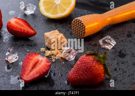 Holz- saftpresse mit Zitrone und Erdbeeren Schichten auf Stein, Barkeeper cocktail Stockfoto