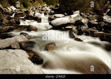 Schnell fließenden Fluss Strom von Wasser aus den Bergen von großen Felsen im Flussbett. Stockfoto