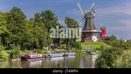 Windmühlen entlang des Flusses in Greetsiel, Deutschland Stockfoto