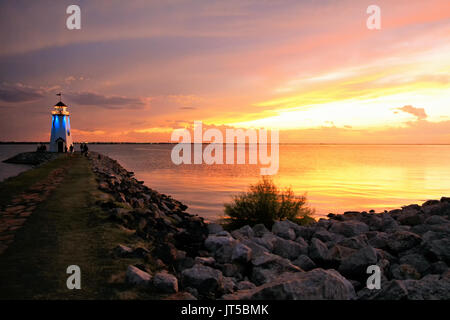 Der Leuchtturm am See Hefner leuchtet in blau leuchten mit einem schönen Oklahoma Sonnenuntergang im Hintergrund. Stockfoto