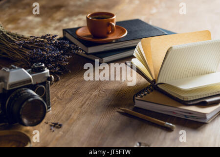 Vintage Foto Kamera, und Tagebücher und Tasse Kaffee auf hölzernen Tischplatte Stockfoto