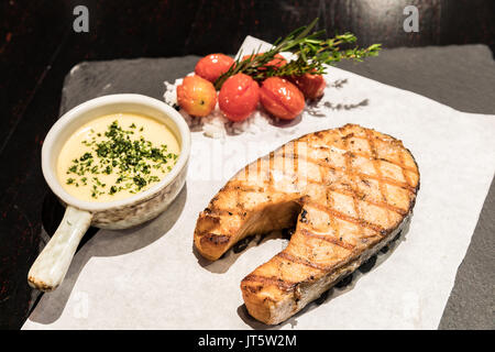 Gegrilltes Lachssteak mit gegrillten Tomaten ans Meer Salz Stockfoto
