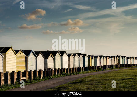 Reihe von bunten Badekabinen entlang Lancing Strand Grün in Lancing, West Sussex Stockfoto