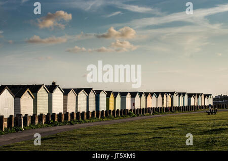 Reihe von bunten Badekabinen entlang Lancing Strand Grün in Lancing, West Sussex Stockfoto