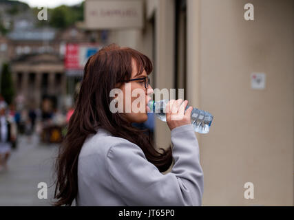 Eine weibliche Straße canvaser Trinkwasser an einem bewölkten und feuchten Tag in Dundee, Großbritannien Stockfoto