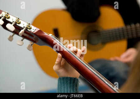 Junge Mädchen, Teenager, lernen, wie man die Gitarre zu spielen. Hand Akkorde spielen, close-up Stockfoto