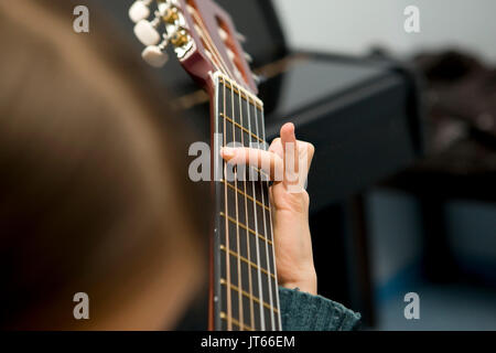 Junge Mädchen, Teenager, lernen, wie man die Gitarre zu spielen. Hand Akkorde spielen, close-up Stockfoto