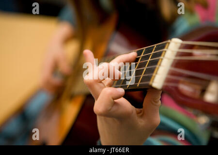 Junge Mädchen, Teenager, lernen, wie man die Gitarre zu spielen. Hand Akkorde spielen, close-up Stockfoto