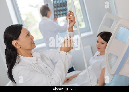 Angenehme positive Arzt Einrichten der IV System Stockfoto