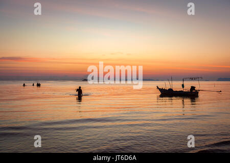 Thailändische fischer Silhouetten während einer bunten tropischen Sonnenuntergang, Nathon Strand von Laem Yai, Koh Samui, Thailand Stockfoto