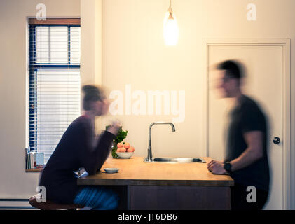 Gemütliches Ambiente und Blurry Paar mit einem Drink vor eine flache Wand Perspektive in der Küche Stockfoto