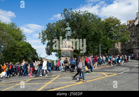 Eine große Masse von Menschen Überqueren einer Kreuzung von der Market Street und dem Damm während des Edinburgh Festival Fringe 2017. Stockfoto