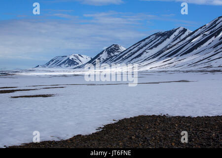 Schneebedeckte Berge und Schnee, Mushamna, Woodfjorden. im Juni, Spitzbergen, Svalbard, Norwegen Stockfoto