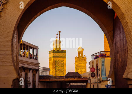 Das Leben auf der Straße. Die Medersa Bou Inania Minarett, Bab Bou Jeloud Tor, Haupteingang Souk Medina von Fes, Fes el Bali. Marokko, Maghreb North Afric Stockfoto