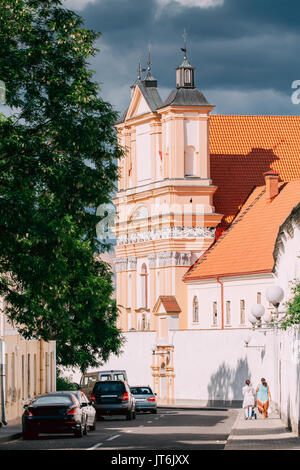 Grodno, Weißrussland. Menschen zu Fuß in der Nähe der katholischen Kirche der Verkündigung der Heiligen Jungfrau Maria und ein Gästehaus! Kloster am sonnigen Sommertag in Stockfoto