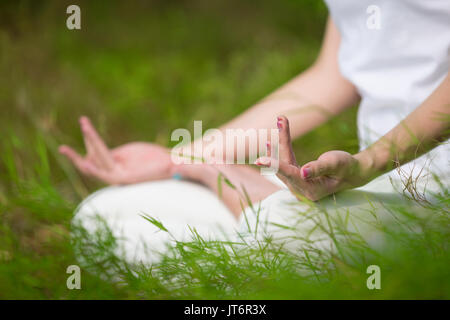In der Nähe der Hände ist eine asiatische Frau Yoga in einem Garten. gesunder Lebensstil und Entspannung Stockfoto