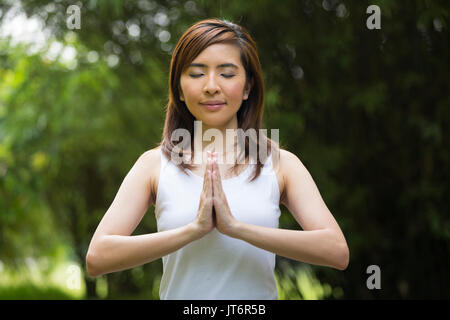 Junge asiatische Frau Yoga in einem Garten. gesunder Lebensstil und Entspannung Stockfoto