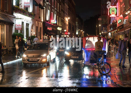 Eine Ansicht der Frith Street, mit Ronnie Scott's Jazz Club und Bar Italia, und mit einem Zyklus tuktuk warten auf eine Fahrt. Aus einer Reihe von Fotos, die o Stockfoto