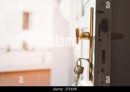 Tür Schlüssel in Schlüsselloch auf alte weiße Holztüren Stockfoto