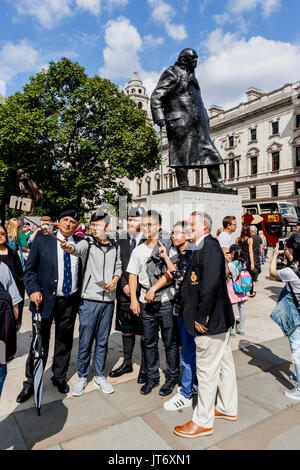 British Army Veterans posieren für Fotos mit chinesischen Touristen in Parliament Square vor einem Marsch gegen Terror, London, UK Stockfoto