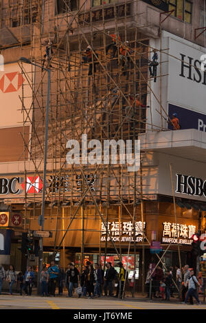 Bauarbeiter bauen eine Bambus Gerüste im Sonnenuntergang an der Nathan Road in Kowloon (Hongkong) Stockfoto