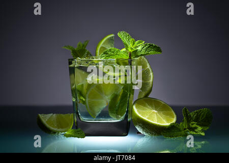 Cocktail mit Kalk, Eis und Pfefferminze Blätter auf einem Glastisch in bar. Stockfoto