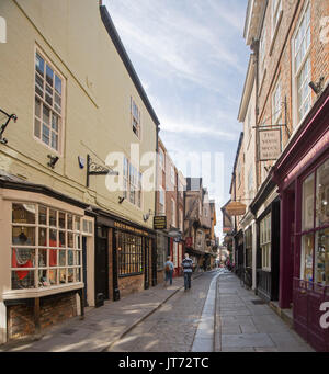 Historische Geschäfte Futter alten engen gepflasterten Straße in The Shambles in York, England mit Fußgänger entlang wandern Stockfoto