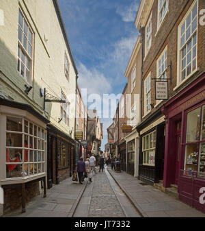 Historische Geschäfte Futter alten engen gepflasterten Straße in The Shambles in York, England, mit Fußgängern durch wandern können. Stockfoto