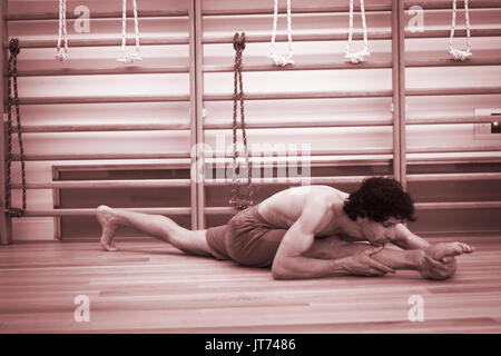 Männliche Yogalehrer tun teilt Gymnastik und Yoga Asanapraxis im Fitness-Studio Fitness Pilates-Studio. Stockfoto