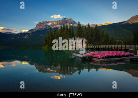 Kanus auf See mit schönen Emerald Lake Lodge und Restaurant im Hintergrund bei Sonnenuntergang, Yoho National Park, Kanada. Stockfoto