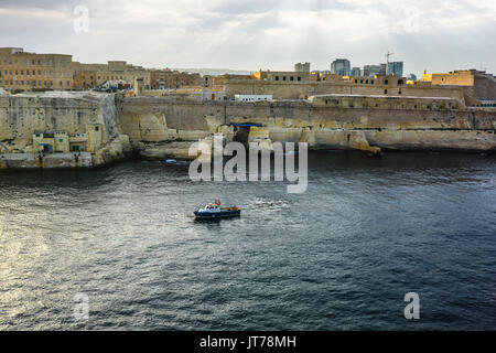 Der Hafen der Stadt Valletta Malta im Mittelmeer mit der steinernen Stadtmauer und ein Boot auf dem Meer Stockfoto