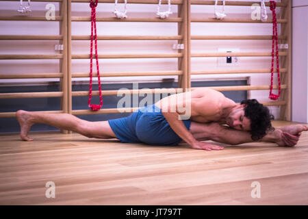Männliche Yogalehrer tun teilt Gymnastik und Yoga Asanapraxis im Fitness-Studio Fitness Pilates-Studio. Stockfoto