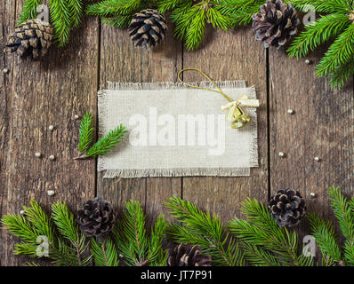 Karte Rahmen mit Tannenzweigen mit New Year's Spielzeug auf einer hölzernen Hintergrund Stockfoto