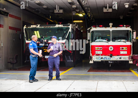 Washington DC, USA - Juli 3, 2017: Happy Feuerwehrleute Feuerwehrleute lächelnd in der Innenstadt von Trucks im Fire Station Stockfoto