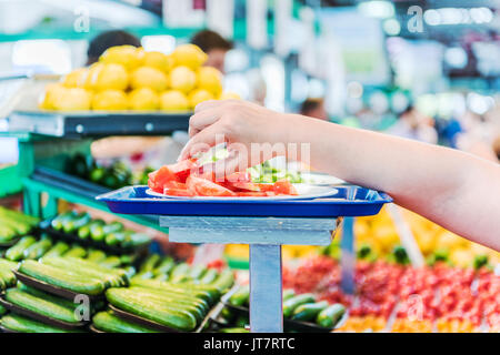 Woman's Hand erreichen für tomatenscheiben Proben bei Farmer's Market Stockfoto