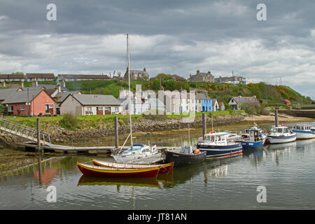 Fischerboote im Hafen, bei der die Zeile der bunten Häuser in der Nähe am Fuße des Hügels im Dorf Helmsdale, Schottland Stockfoto