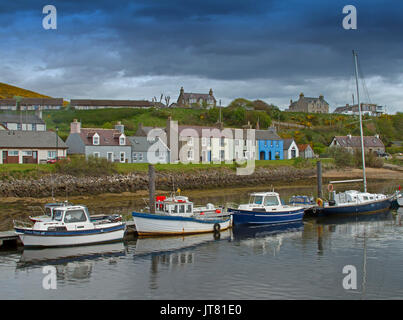 Fischerboote im Hafen, bei der die Zeile der bunten Häuser in der Nähe am Fuße des Hügels im Dorf Helmsdale, Schottland Stockfoto