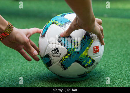 München, Deutschland. 8 Aug, 2017. Ein FC Bayern München Mitarbeiter stellen einen Ball auf einige Kunstrasen auf der offiziellen Team Foto der Gruppe in der Allianz Arena in München, Deutschland, 8. August 2017. Foto: Peter Kneffel/dpa/Alamy leben Nachrichten Stockfoto