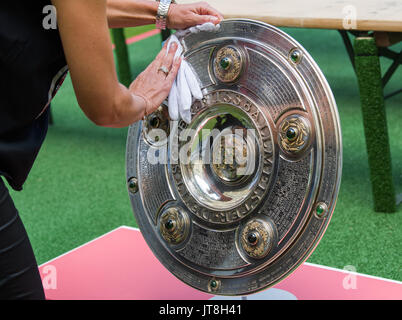 München, Deutschland. 8 Aug, 2017. Ein FC Bayern München Mitarbeiter Polituren der Deutsche Fußball-Bund (DFB) Meisterschaft Schild auf der offiziellen Team Foto der Gruppe in der Allianz Arena in München, Deutschland, 8. August 2017. Foto: Peter Kneffel/dpa/Alamy leben Nachrichten Stockfoto